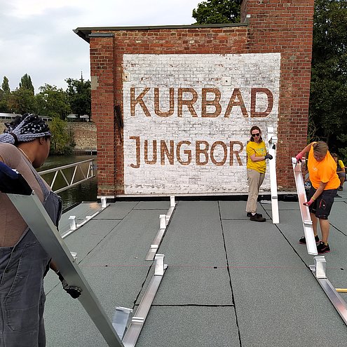 Frauen* bereiten die Unterkonstruktion einer PV-Anlage vor